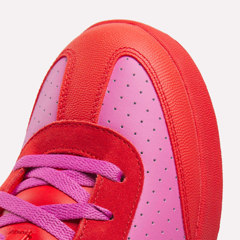 Close-up of the Reebok x BBC Board Flip Skate Shoes, featuring a bold red and pink colorway with pink laces, perforated pink leather, and red suede and fabric accents—ideal for standout street style.
