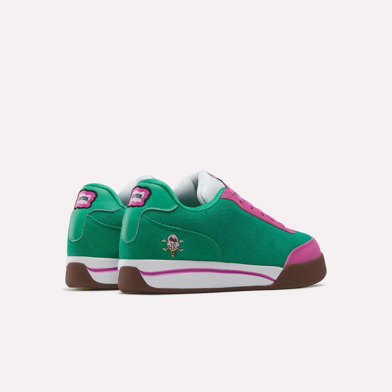The Reebok x BBC Board Flip Skate Shoes feature a green upper with pink and brown accents, white midsoles, and a cartoon character on the heel. Inspired by early-2000s style, they're displayed to show both side and back views.