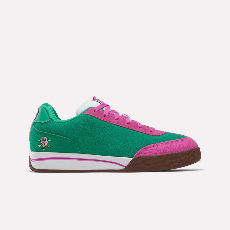 The Reebok x BBC Board Flip Skate Shoes by Reebok feature a green and pink low-top design with suede accents, brown sole, white laces, and a small cartoon character embroidered near the heel.
