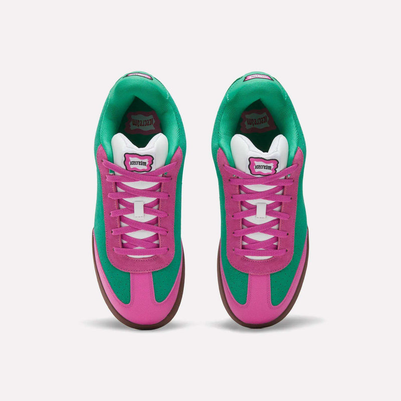 Top view of Reebok x BBC Board Flip Skate Shoes with bright green suede sides, vibrant pink overlays, white laces, and gum-colored outsoles on a plain white background.