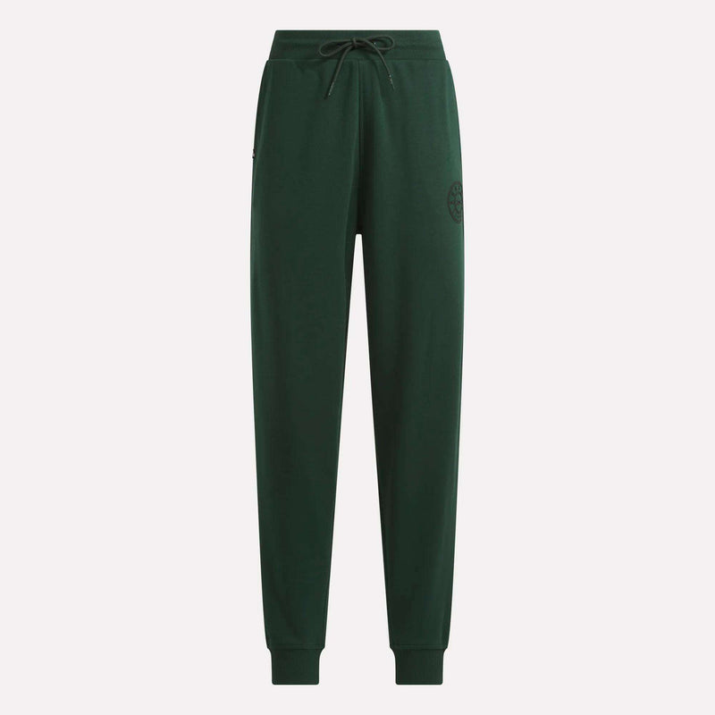 The Women’s French Terry Joggers by Reebok feature a dark green color, an elastic waistband with a black drawstring, cuffed ankles, and a subtle Reebok logo on the left thigh. Crafted from soft French terry fabric for outstanding comfort, these joggers highlight Reebok’s heritage design aesthetic and are shown against a plain light background.
