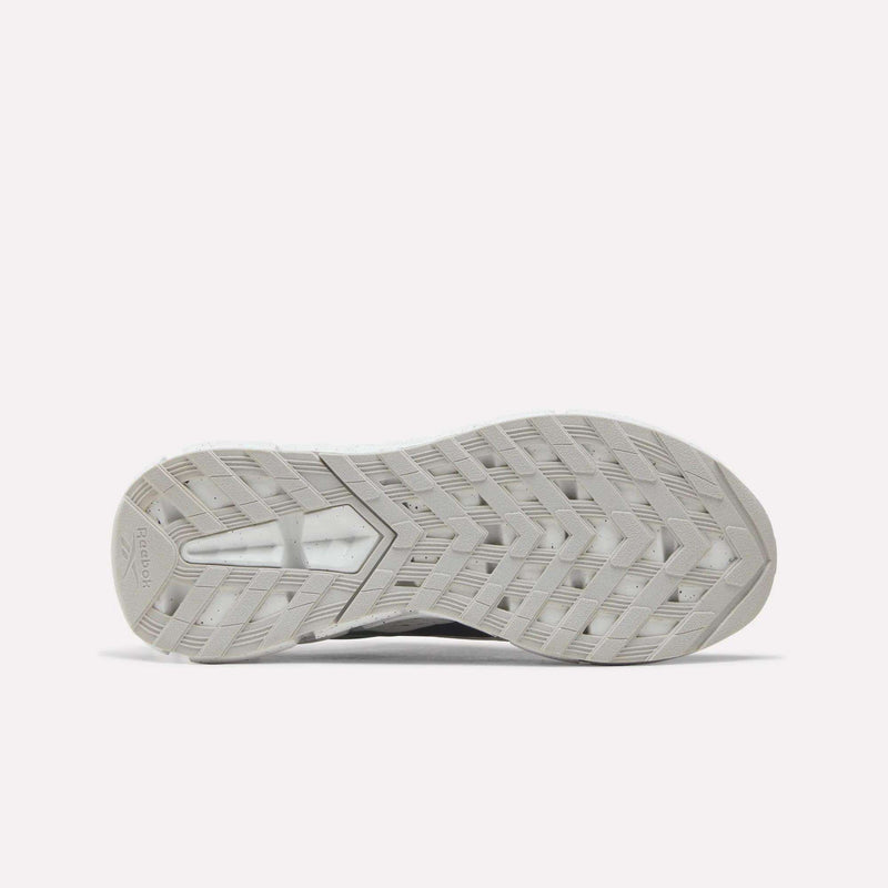 The image displays the gray, textured sole of the Reebok Zig Dynamica 6 Running Shoes for Big Kids, featuring a distinctive zigzag tread pattern with Zig technology, as seen from the bottom against a plain white background.