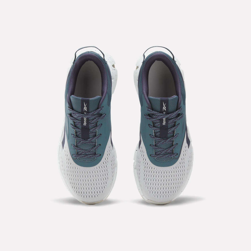 A pair of Zig Dynamica 6 Running Shoes for big kids by Reebok in teal and white, viewed from above to display their mesh fabric, laces, and the Reebok logo on each tongue. Featuring innovative Zig technology, these athletic shoes offer a perfect blend of comfort and style for active lifestyles.