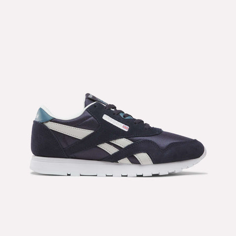 A pair of Reebok Classic Nylon Shoes for Big Kids in Dark Indigo, New Grey 1, and Midnight Tide is shown in profile against a plain light background. Featuring a white sole, dark indigo suede overlays, and crisp side stripes, these sneakers combine comfort with timeless style—making them an excellent choice for boys’ footwear.