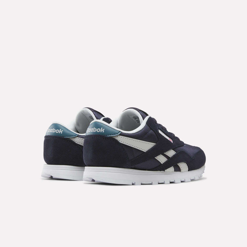 A pair of Reebok Classic Nylon Shoes - Little Kids in navy blue and white with teal accents are positioned side by side on a light background, facing away and slightly to the left, making them a stylish choice for boys.