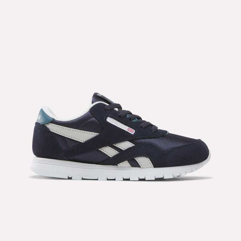 A Reebok Classic Nylon Shoe for little kids in Dark Indigo, New Grey 1, and Midnight Tide, featuring a white sole, side stripe design, and mesh accents. This boys’ sneaker is shown from the side against a plain white background.