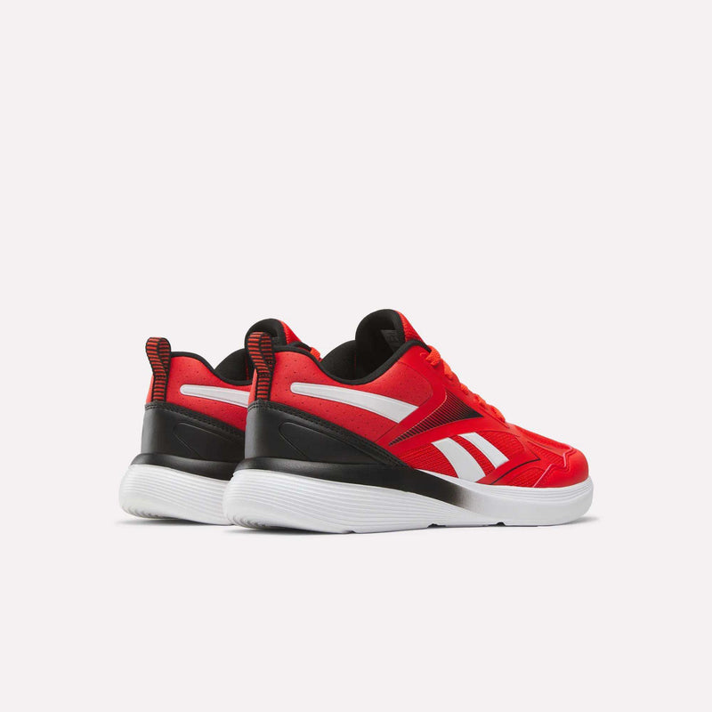 The Reebok Rush Runner 6.0 Running Shoes for big kids feature a red design with white soles, black heel accents, white side stripes, and red pull tabs at the back, displayed on a plain white background.