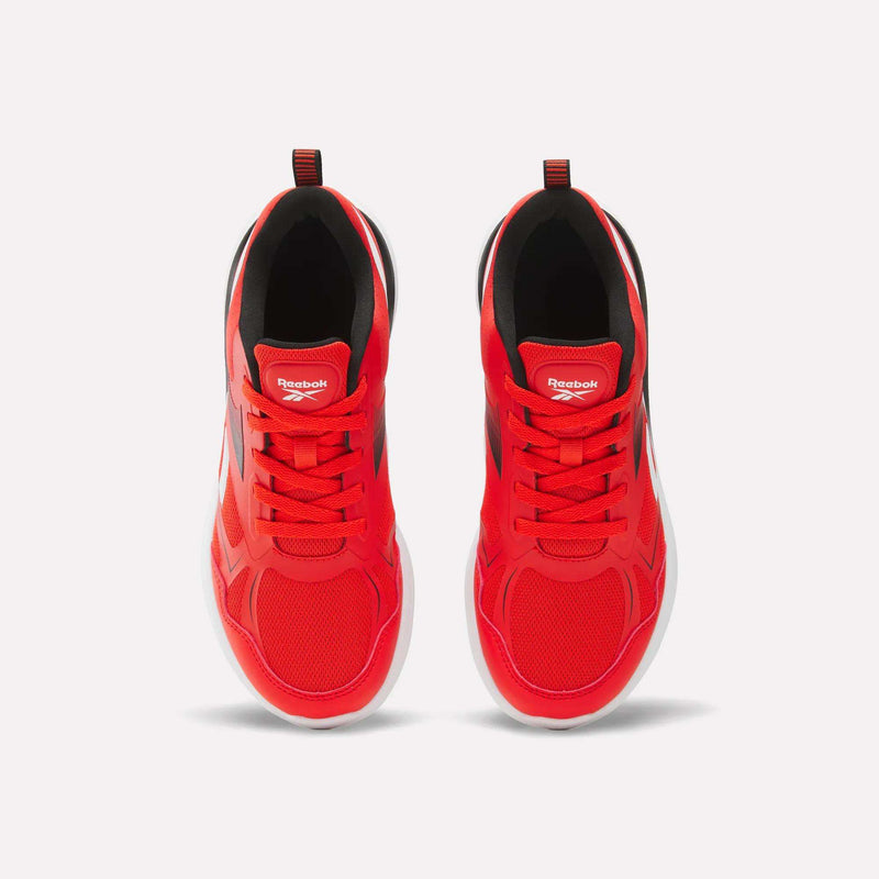 Top view of bright red Reebok Rush Runner 6.0 Running Shoes for big kids, featuring white EVA midsoles, black interior lining, red laces, and the Reebok logo on each tongue—a bold athletic choice.