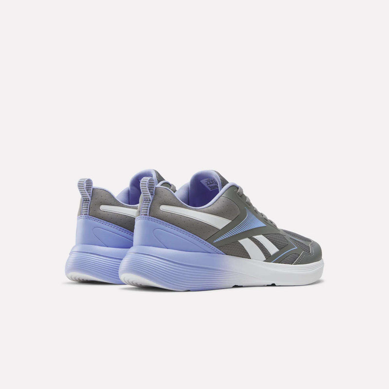 A pair of Reebok Rush Runner 6.0 Running Shoes for big kids in gray and lavender with white soles and accents, featuring an EVA midsole for enhanced comfort, displayed at an angle on a plain white background.