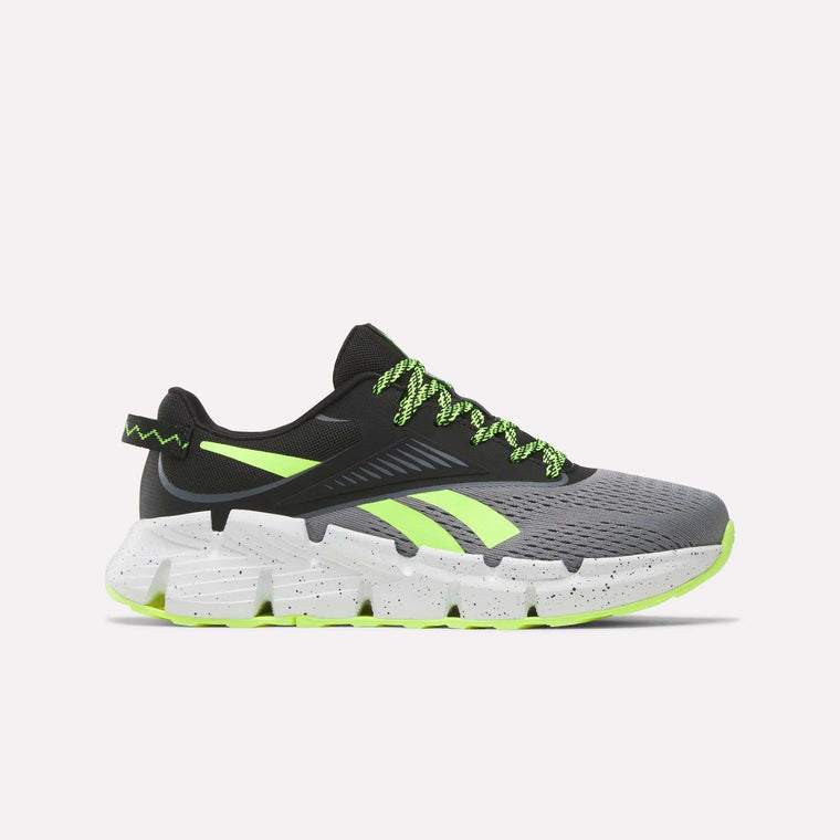 The Reebok Zig Dynamica 6 Running Shoes for big kids in Grey 4/Black/Digital Lime feature neon laces, black detailing, and a chunky speckled sole—engineered with Zig technology for superior running performance.