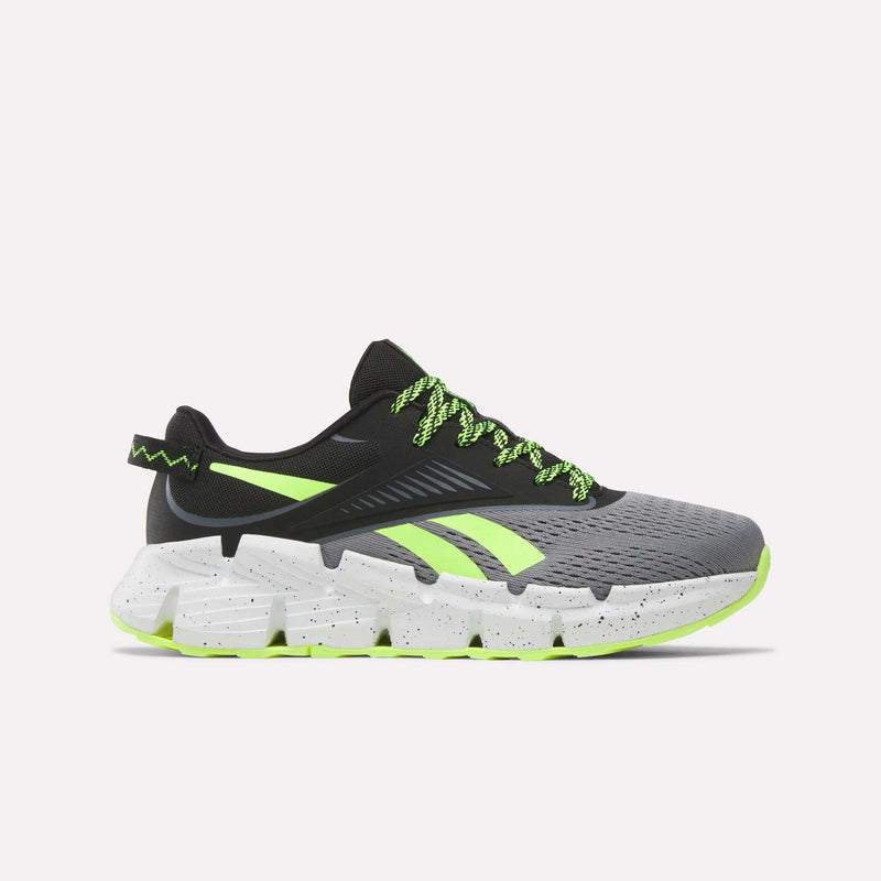The Reebok Zig Dynamica 6 Running Shoes for big kids in Grey 4/Black/Digital Lime feature neon laces, black detailing, and a chunky speckled sole—engineered with Zig technology for superior running performance.