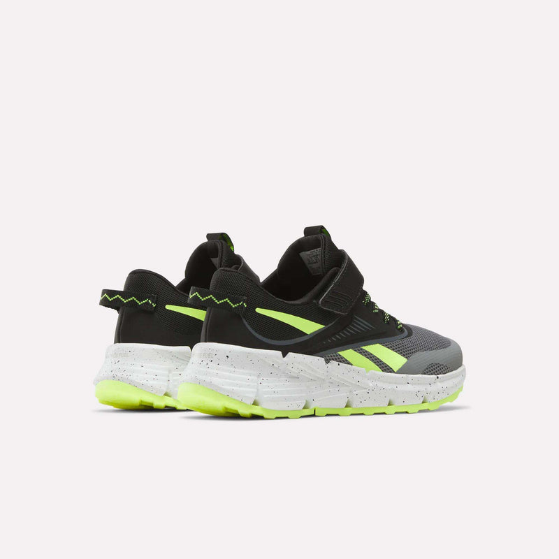 A pair of Reebok Zig Dynamica 6 Running Shoes for little kids in black and gray with neon yellow accents, Zig technology, white speckled soles, and chunky neon outsoles, shown on a plain white background.