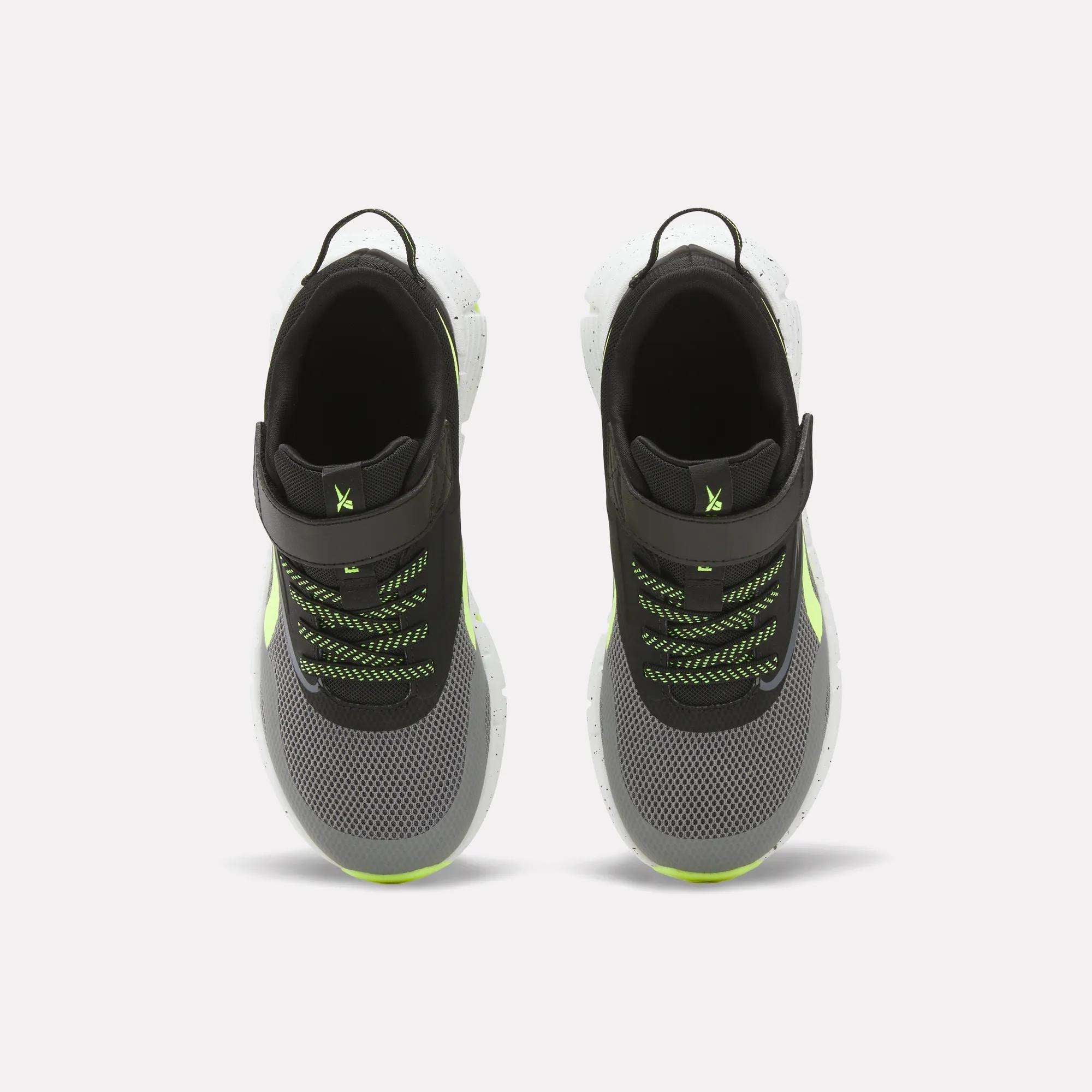 Top view of Reebok Zig Dynamica 6 Running Shoes for little kids in black and gray with neon green accents, white Zig soles, mesh uppers, black pull tabs, and green/black laces on a white background.