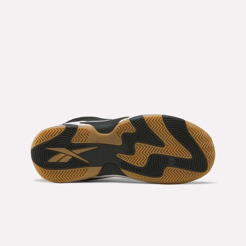 The image shows the sole of the Reebok Zone Breaker Shoes for big kids, featuring a black and tan wavy tread pattern and the Reebok logo on the left side, designed to provide excellent grip and ankle support on the basketball court.