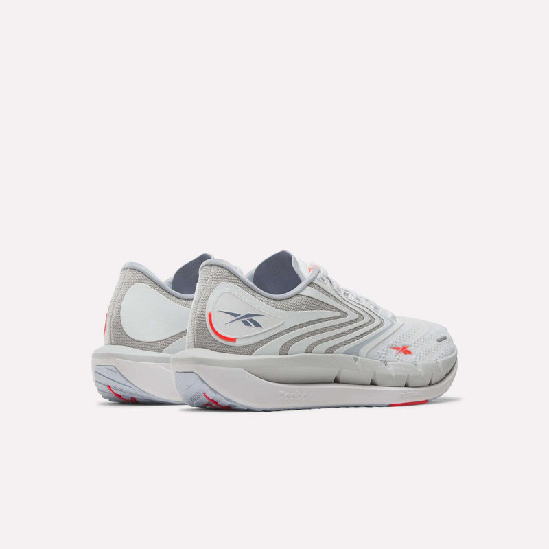 Reebok Women's FloatZig Tread Running Shoes in white and gray feature light gray soles, subtle red accents, and a breathable mesh upper—perfect for treadmill workouts—shown on a white background.