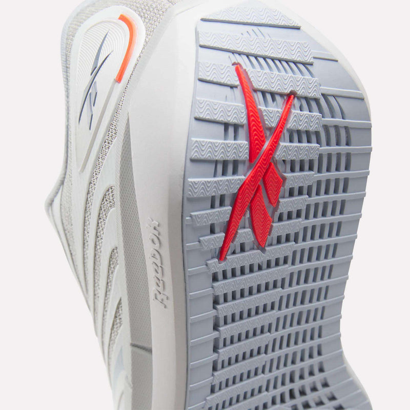 Close-up of the Women's FloatZig Tread Running Shoes by Reebok, showing a textured grey sole with a bold red X design and embossed logo—ideal for treadmill workouts.