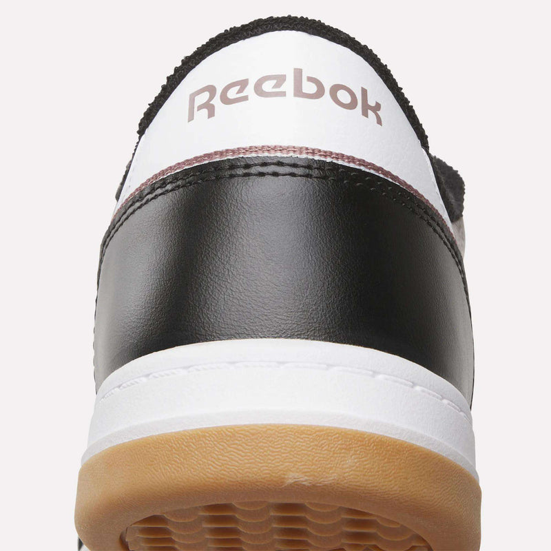 Close-up of the back of the Reebok Men’s Court LXS Shoes in black and white with a gum sole, made from full grain leather and featuring the Reebok logo on the heel—a perfect men’s court shoe.