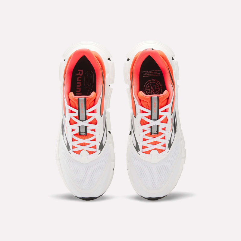 A pair of Reebok Men's FloatZig 2 Running Shoes with Superfloat+ cushioning, supportive white upper, orange inner lining, gray accents, and white laces is shown from above on a plain light background.