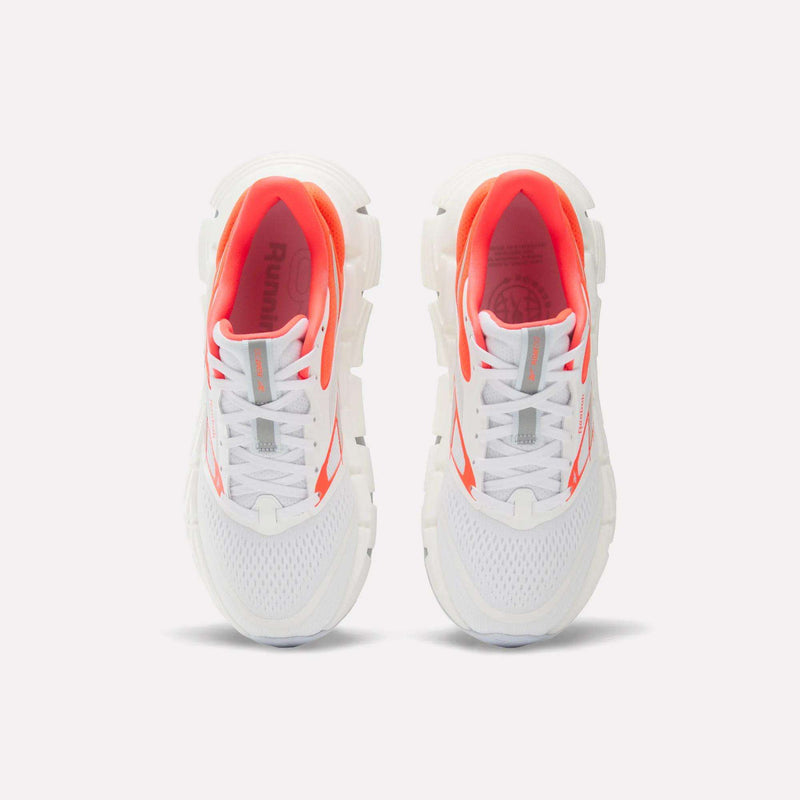 A pair of Reebok Women's FloatZig 2 Running Shoes in white, showcasing breathable mesh uppers, bold orange accents, and chunky soles with Superfloat+ cushioning for exceptional comfort—displayed from above on a light background.