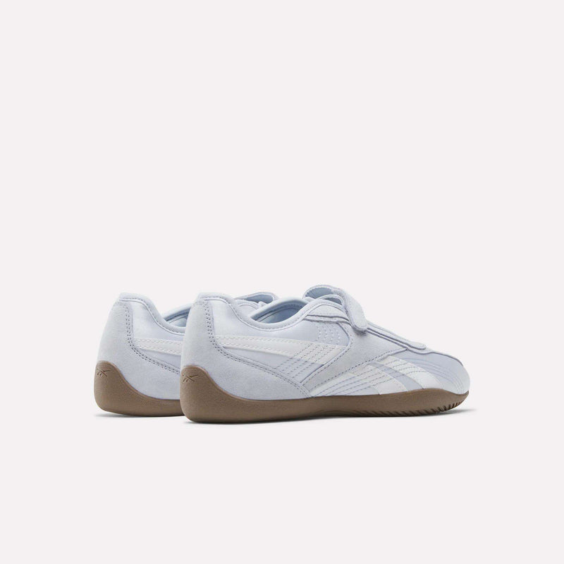 A pair of Women's Ultra Lo Mary Jane Shoes by Reebok, in light grey with white stripes and gum-colored soles, displayed from the back and side against a plain white background.