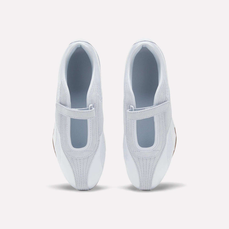 Top view of Women's Ultra Lo Mary Jane Shoes by Reebok in white, featuring Velcro straps and T-shaped cutouts on each upper, displayed on a plain white background with a subtle nod to the mary jane silhouette.