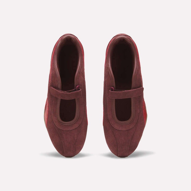 Top view of a pair of Reebok Women’s Ultra Lo Mary Jane Shoes in burgundy suede with a single strap across each foot, displayed side by side on a plain white background.
