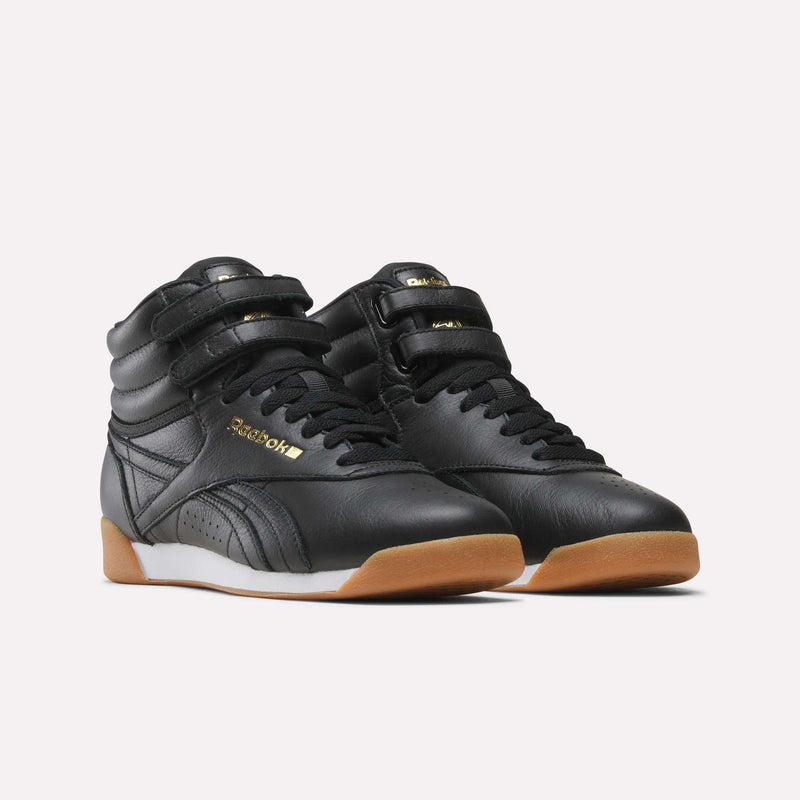 Women’s Freestyle Hi Shoes in black with two hook-and-loop straps across the ankle, black laces, and a gum-colored rubber sole.