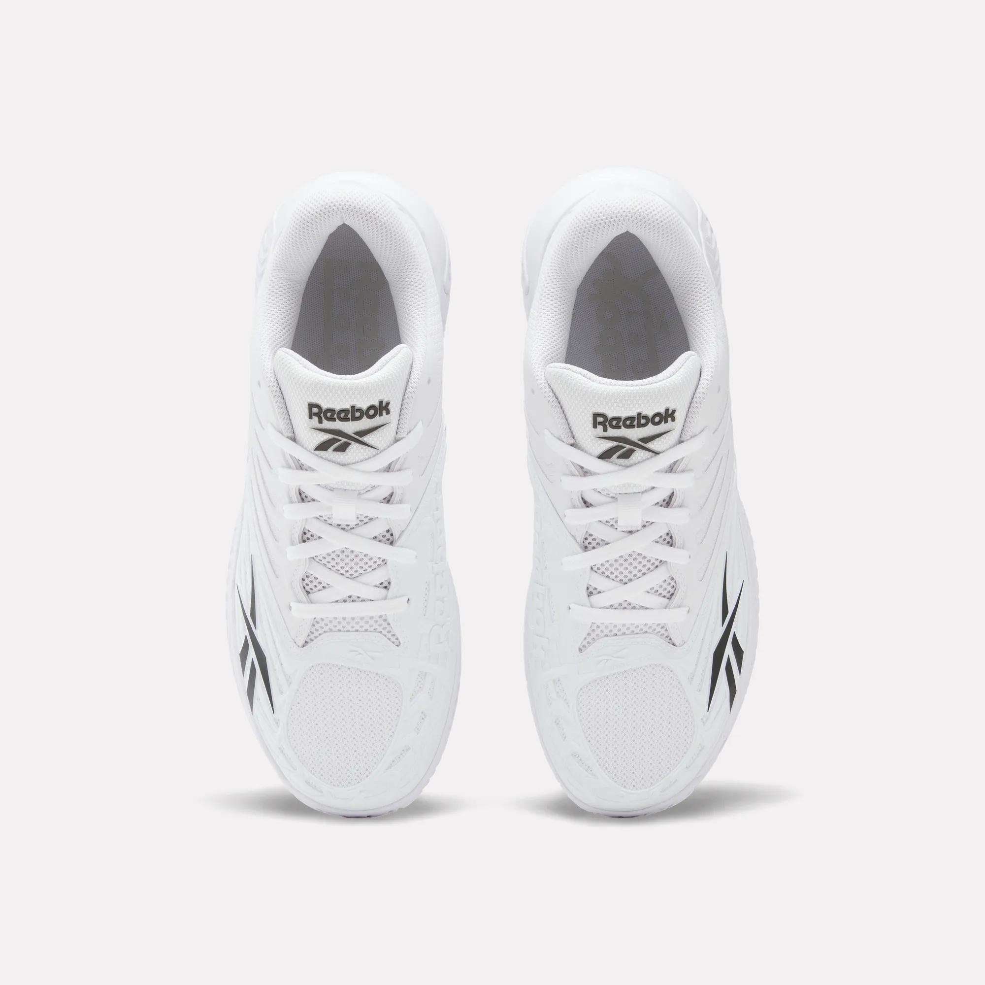 Top view of a pair of Reebok Phase EVO Tennis Shoes in white with black Reebok logos on the sides and tongue, displayed side by side on a plain white background.