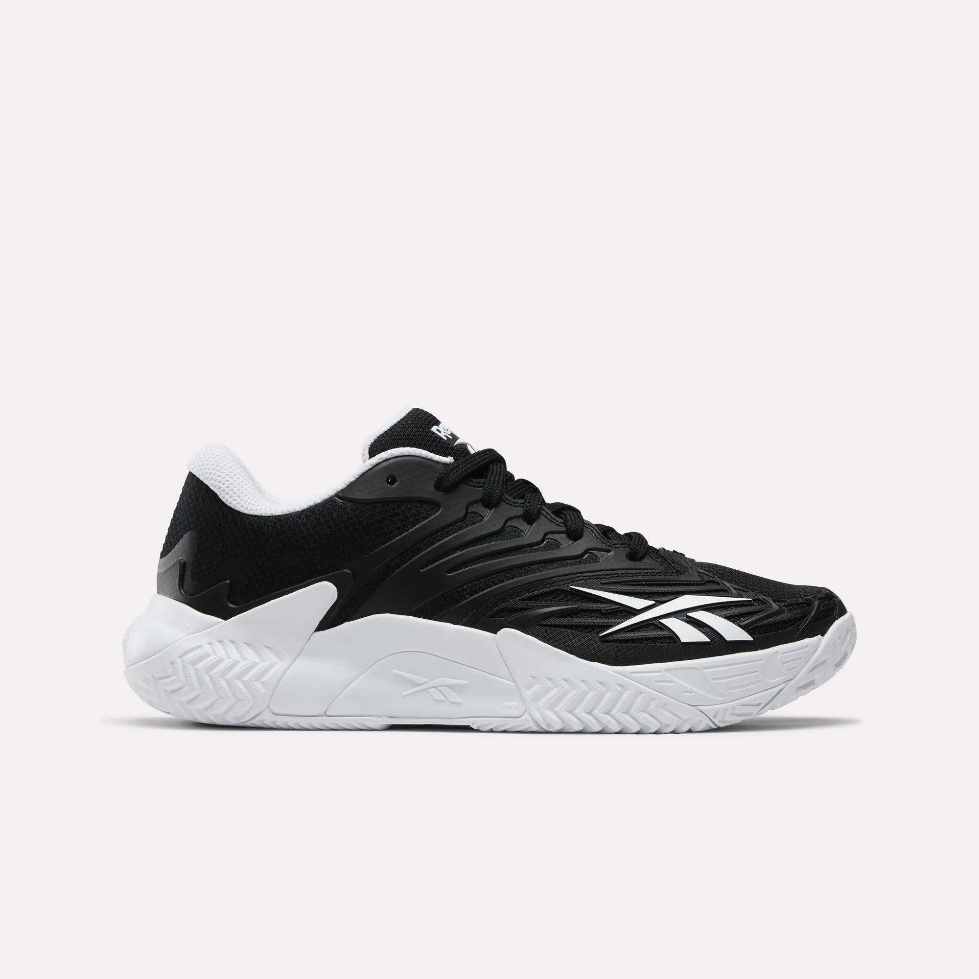 The Reebok Women's Phase Evo Tennis Shoes feature a black upper with white accents, a textured white sole, the Reebok logo on the side, and a low-cut lace-up design for durability and style.