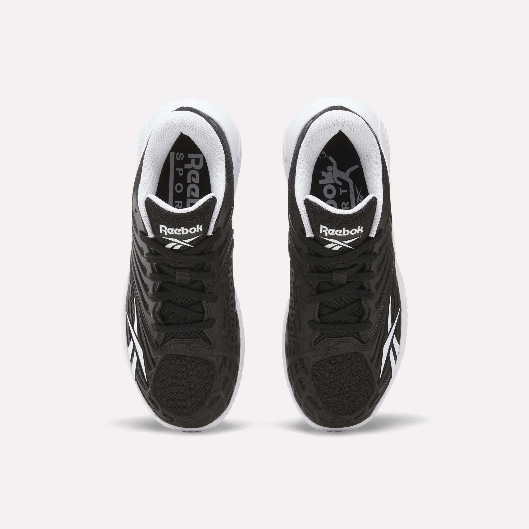 A pair of Reebok Women's Phase Evo Tennis Shoes in black with white accents is shown from above on a light background, featuring the Reebok logo on the tongue and side.