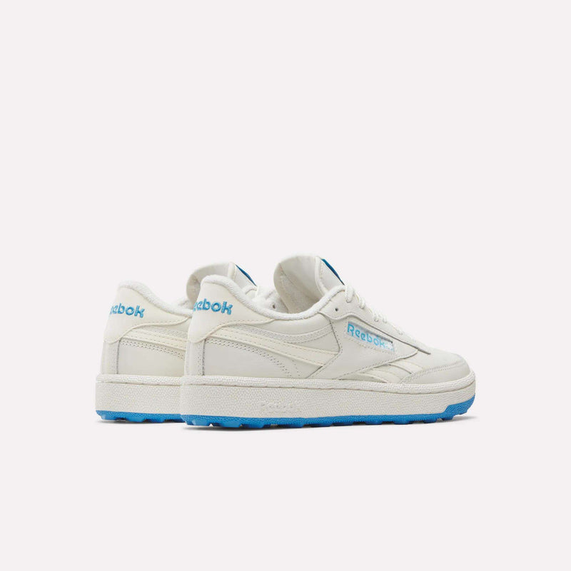 A pair of Reebok Women’s Club C Revenge Golf Shoes in white with light blue accents and blue soles, displayed on a plain white background.