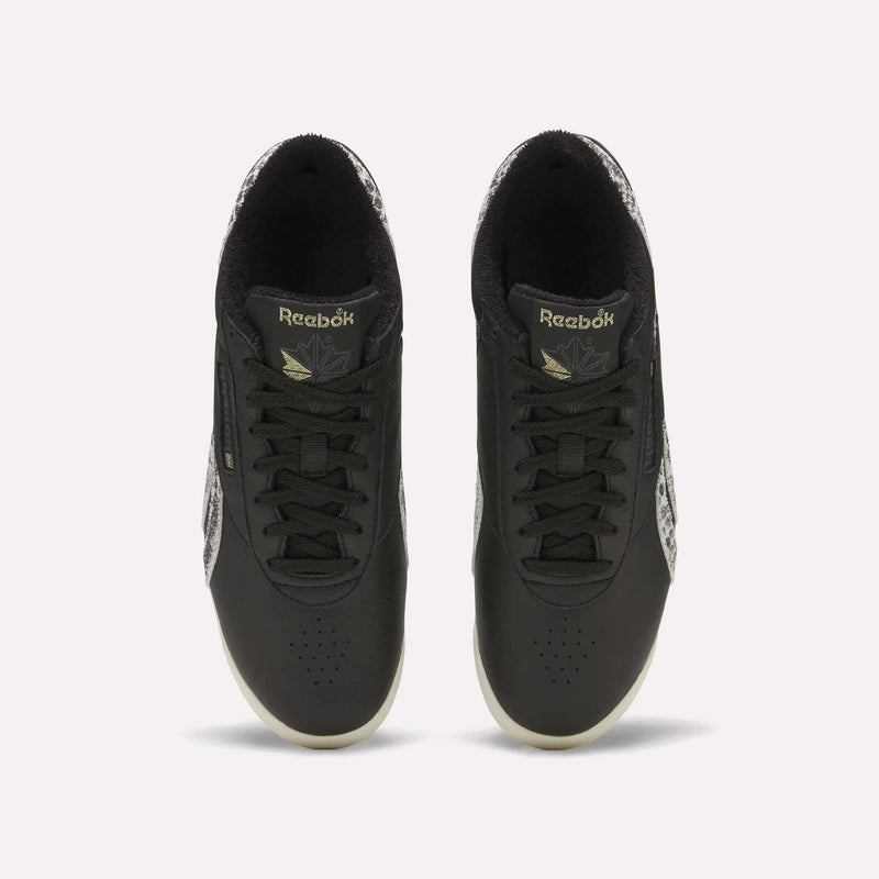 A pair of Reebok Women’s Freestyle Lo Shoes in black with black laces and patterned sides, viewed from above on a plain white background.