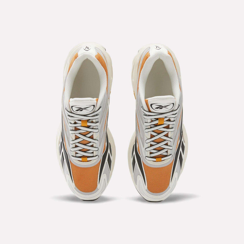 Top view of a pair of Reebok Premier Road 1000 Shoes, featuring white, orange, and black details with white laces, mesh panels, and an EVA midsole, placed side by side on a plain white background.
