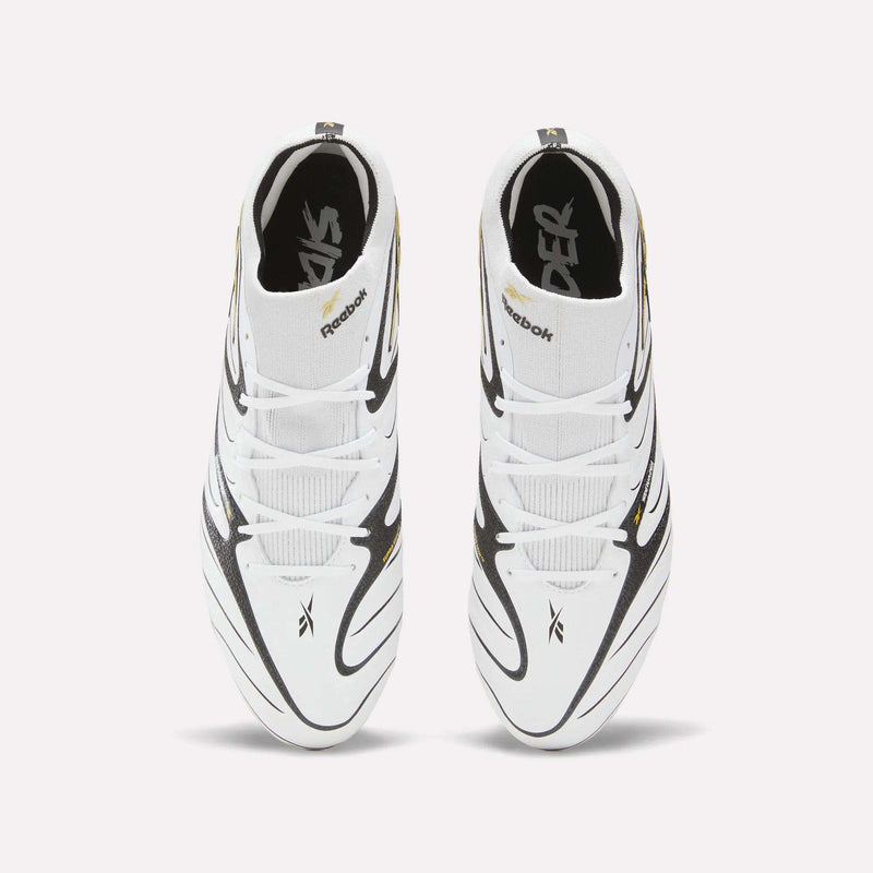 Top view of a pair of Reebok Sidewinder 26 Elite Firm Ground Cleats in white with black and gold accents, featuring crisscrossed designs and Reebok logos on the tongues and sides, set against a plain light background—perfect for ball control on firm grass.