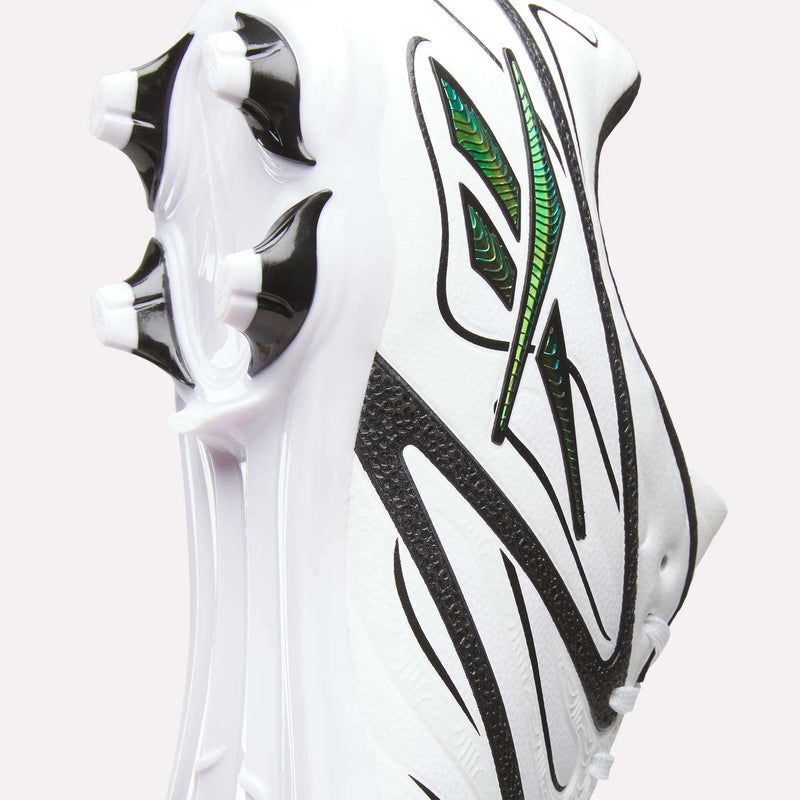 Close-up of the Reebok Sidewinder 26 League Firm Ground Cleats in white, featuring black lines and green accents, with a focus on the firm ground studs designed for enhanced ball control, set against a plain light background.