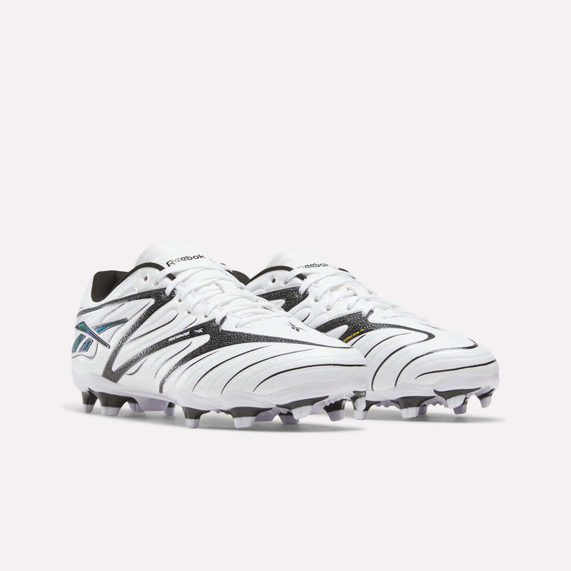 A pair of Reebok Sidewinder 26 League Firm Ground Cleats for big kids, in white with black and silver accents and designed with firm ground studs, are placed side by side on a plain light background.
