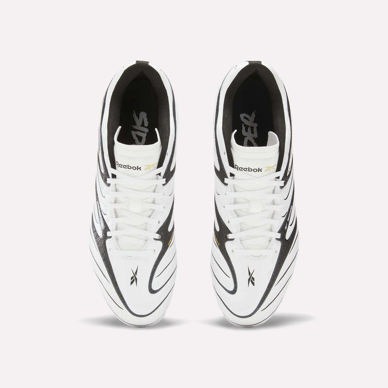 Top view of a pair of Reebok Sidewinder 26 League Firm Ground Cleats for big kids in white, featuring black and gold accents. The image highlights the laces, Reebok logo, design details, and firm ground studs against a plain white background.