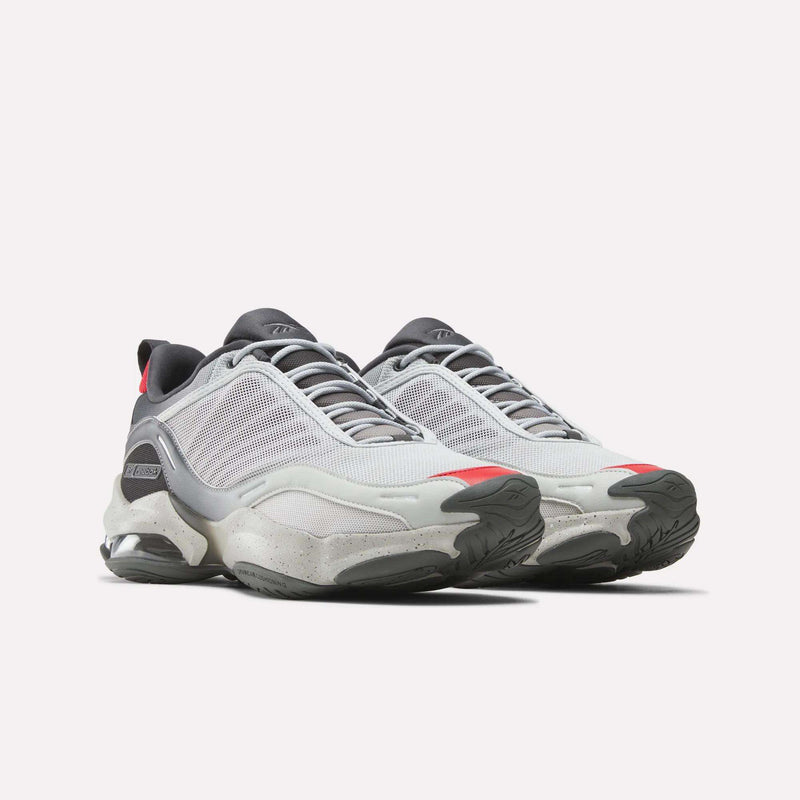 The Mita Sneakers x DMX Series 3000 Shoes by Reebok feature white and gray mesh uppers, thick textured soles, and red accents on the toes and heels, highlighting DMX moving air technology against a light background.