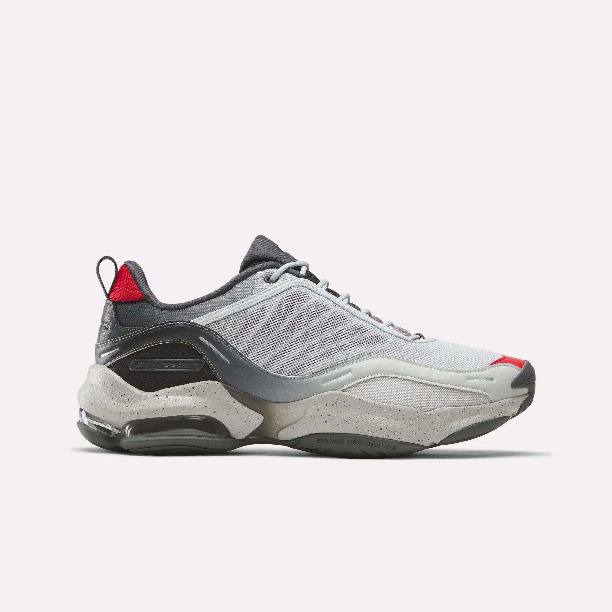 The Reebok Mita Sneakers x DMX Series 3000 Shoes feature a white and gray upper with mesh panels, gray laces, red accents, and a chunky speckled sole with DMX moving air technology for comfort and style.