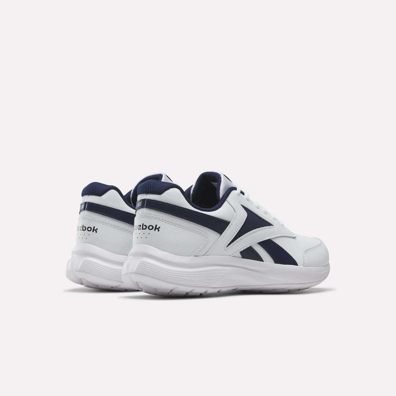 A pair of Reebok Men's Walk Ultra 7 DMX Max Shoes in white with navy blue accents, featuring DMX cushioning for enhanced comfort, are displayed on a plain, light background. The cushioned walking shoes are positioned to highlight the side and back views.