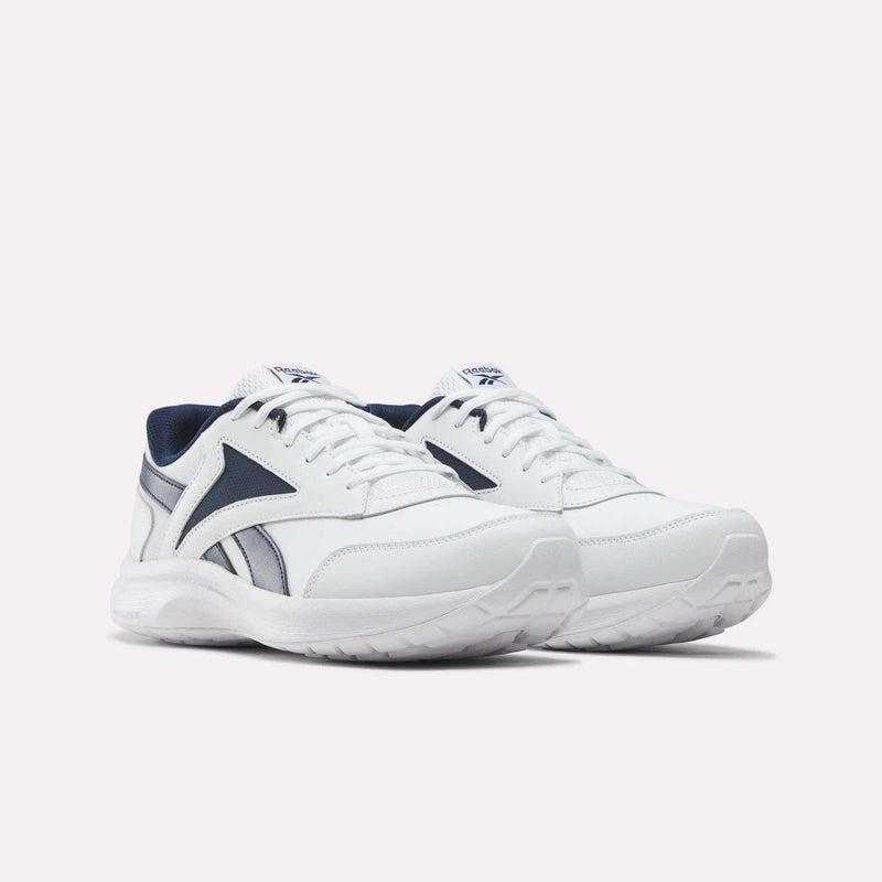 A pair of Reebok Men's Walk Ultra 7 DMX Max Shoes - Wide 4E in white, featuring dark blue accents and logo, is displayed on a plain white background. These wide-fit walking shoes offer white laces and soles, complemented by a dark blue inner lining and detailing for added style, while DMX cushioning delivers optimal comfort with every step.