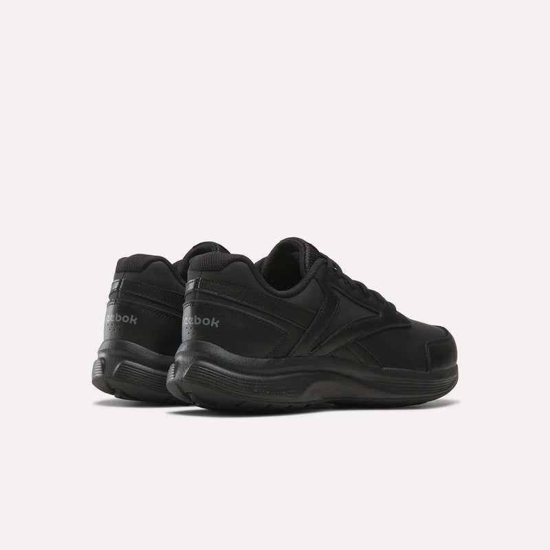 A pair of Men's Walk Ultra 7 DMX Max Shoes - Wide 4E by Reebok are displayed on a white background, angled with the heels facing the camera and toes pointing outward. These black wide-fit walking shoes feature DMX cushioning, delivering comfort and support for everyday wear.
