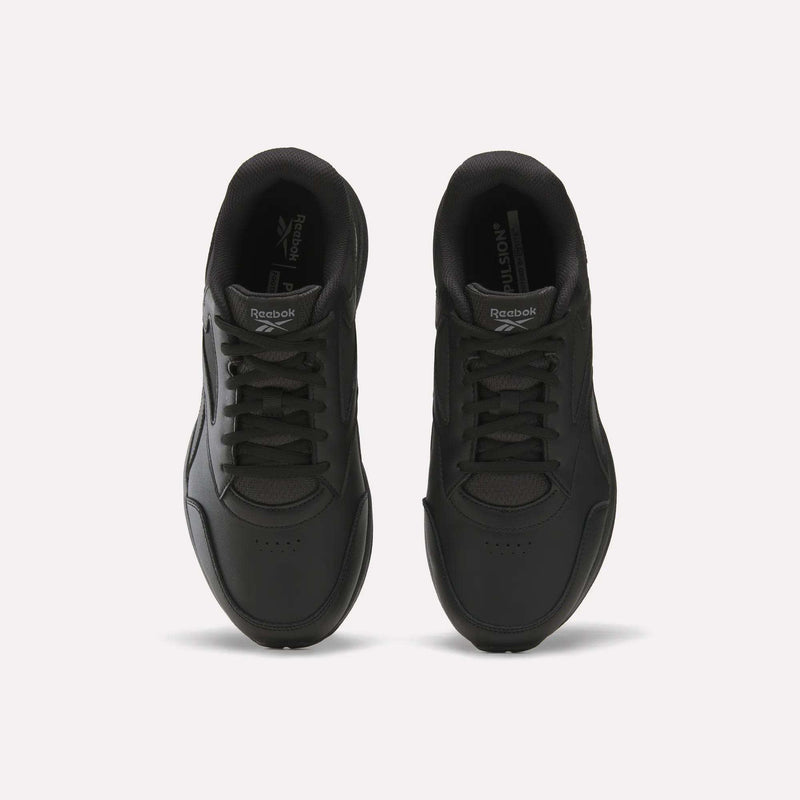 A pair of black Men's Walk Ultra 7 DMX Max Shoes - Wide 4E by Reebok is shown from above, highlighting the laces, toe area, and Reebok branding on the tongues, set against a plain white background. These wide-fit walking shoes are equipped with DMX cushioning for added comfort and support.