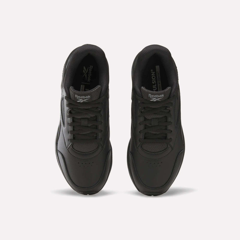 Top view of a pair of Women’s Walk Ultra 7 DMX Max Shoes by Reebok in black, featuring laces and positioned side by side on a plain white background. The Reebok logo is visible on the tongue and insole of each shoe, emphasizing their cushioned design for all-day comfort.