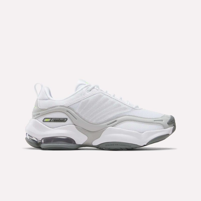 The Reebok Women’s DMX Series 3000 Shoes in White/New Grey 1/Digital Lime feature a mesh upper, thick sole, and DMX moving air technology that delivers visible air cushioning in the heel for ultra-cushioned comfort and lightweight support, shown on a plain white background.