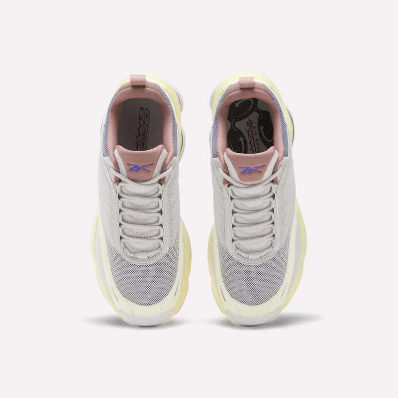 A top view of the Reebok Women's DMX Series 3000 Training Shoes in light gray and white, featuring pink and pale yellow accents, mesh toe boxes, and the Reebok logo on the tongue. These cushioned shoes are designed with innovative DMX 3 Technology and are displayed side by side on a plain white background.