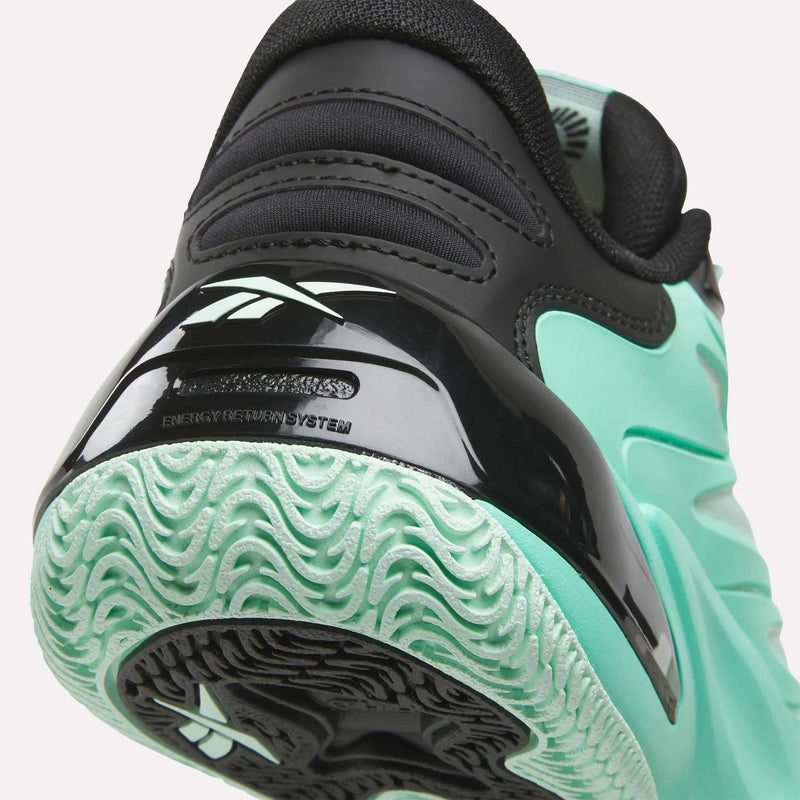 Close-up of the heel and sole of a mint green and black Reebok Angel Reese 1 Basketball Shoe, showcasing its textured mint green tread, black accents, and a portion of the Reebok logo. Engineered with the innovative Reebok Energy Return System for enhanced support during on-court performance.
