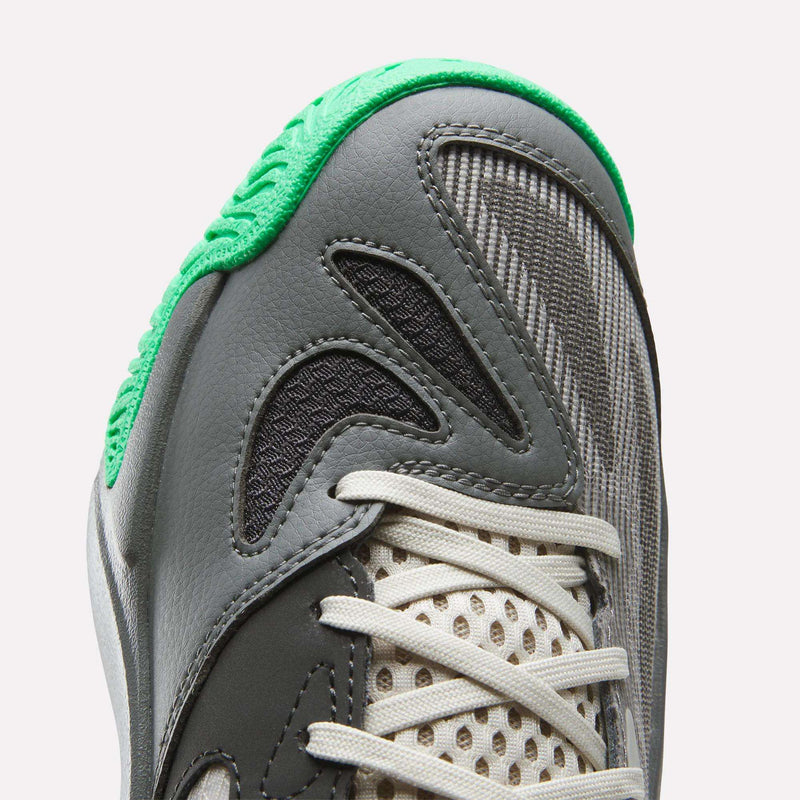 Close-up of the toe area of the Reebok Engine A 26 Basketball Shoes, showcasing gray and black panels, white laces, engineered mesh upper detailing, and a textured green rubber trim along the edge of the sole.