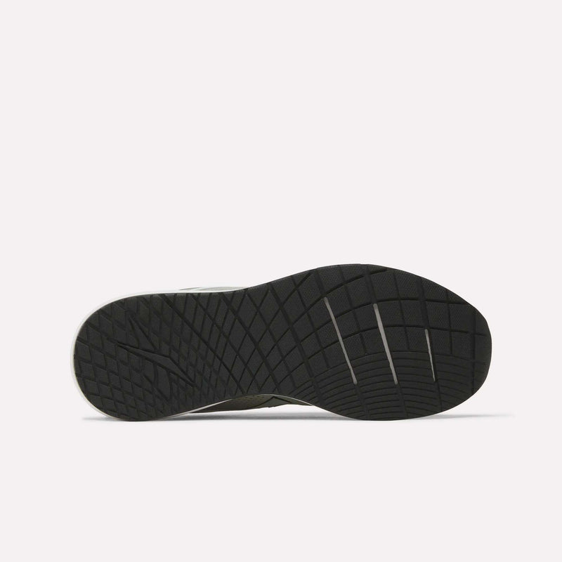 The image displays the black rubber outsole of a Reebok Men's Nanoflex 2 Training Shoe, highlighting its geometric tread pattern and several horizontal flex grooves, set against a plain white background.