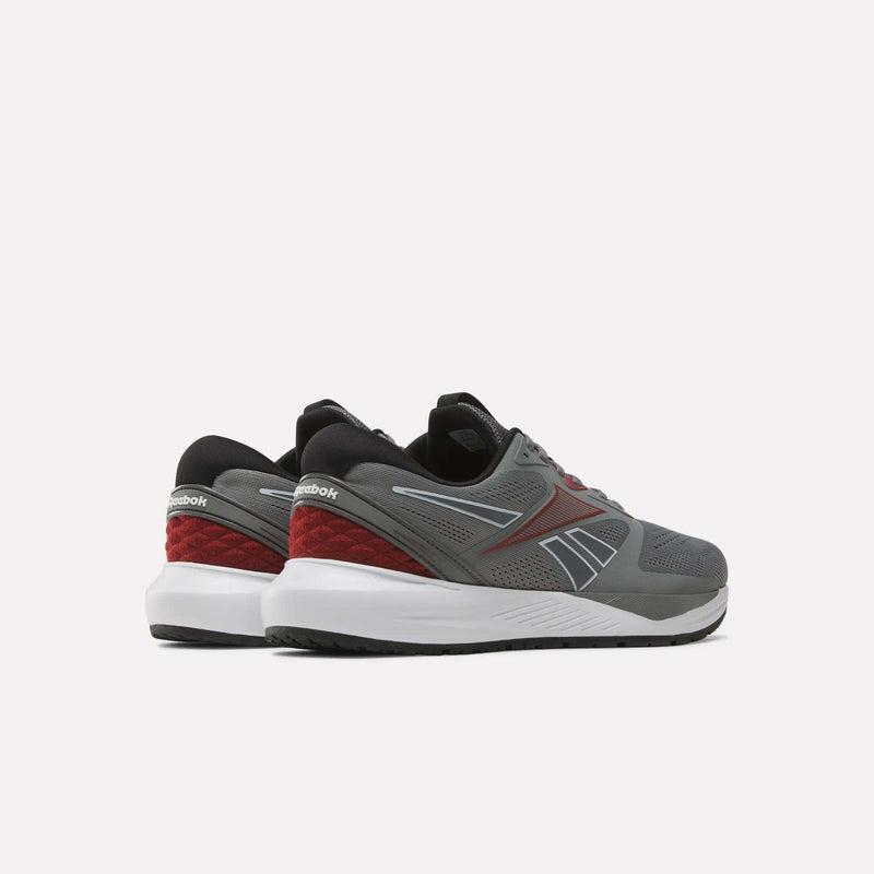 A pair of Reebok Men's Nanoflex 2 Training Shoes in gray with black, red, and white accents are displayed on a plain white background, shown from the back and side angles. These shoes feature a breathable mesh upper designed to provide enhanced comfort during intense training sessions.